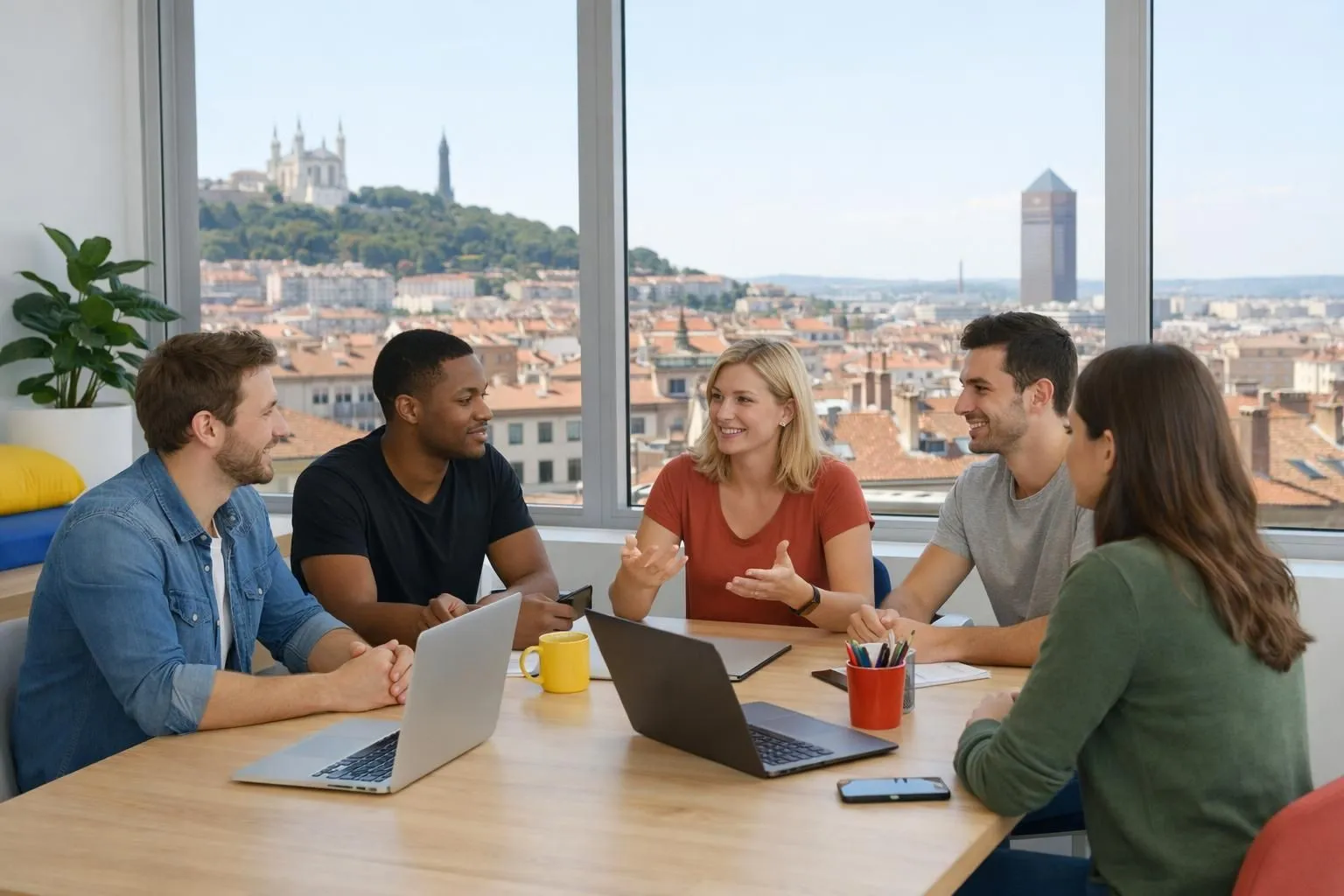 Équipe de développeurs web collaborant autour d'écrans affichant l'interface WordPress dans un bureau lumineux et moderne à Lyon, avec vue sur les toits lyonnais en arrière-plan