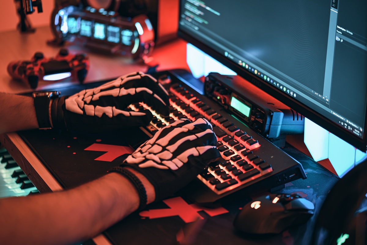 a person wearing a skeleton glove typing on a keyboard
