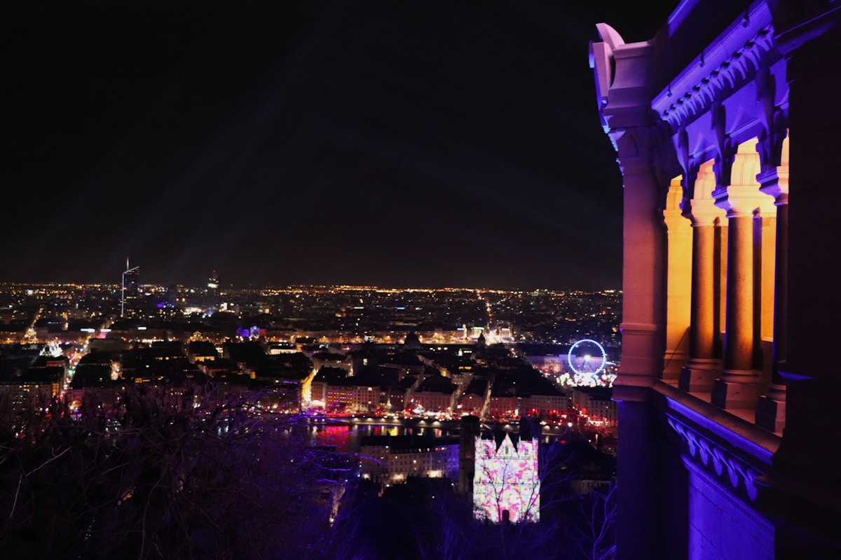 Cityscape illuminated at night with colorful lights.