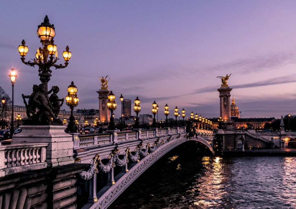 "Un pont illuminé la nuit à Paris, symbole de la création site internet Paris réussie"