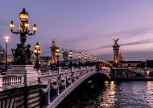 "Un pont illuminé la nuit à Paris, symbole de la création site internet Paris réussie"