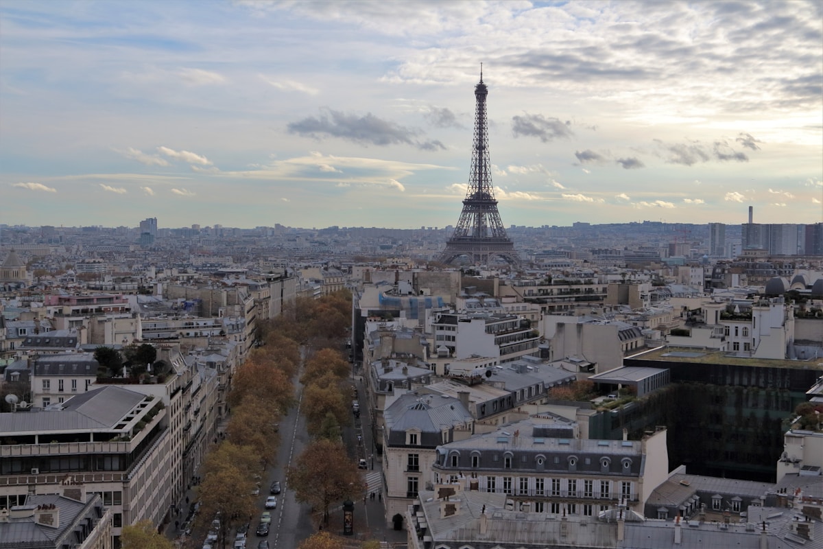 Tour Eiffel dominant le paysage parisien sous un ciel nuageux.