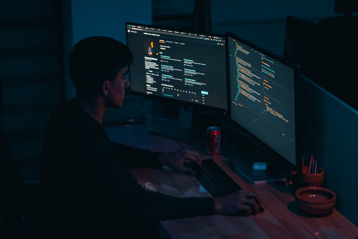 Programmeur travaillant tard dans la nuit sur des lignes de code complexes.