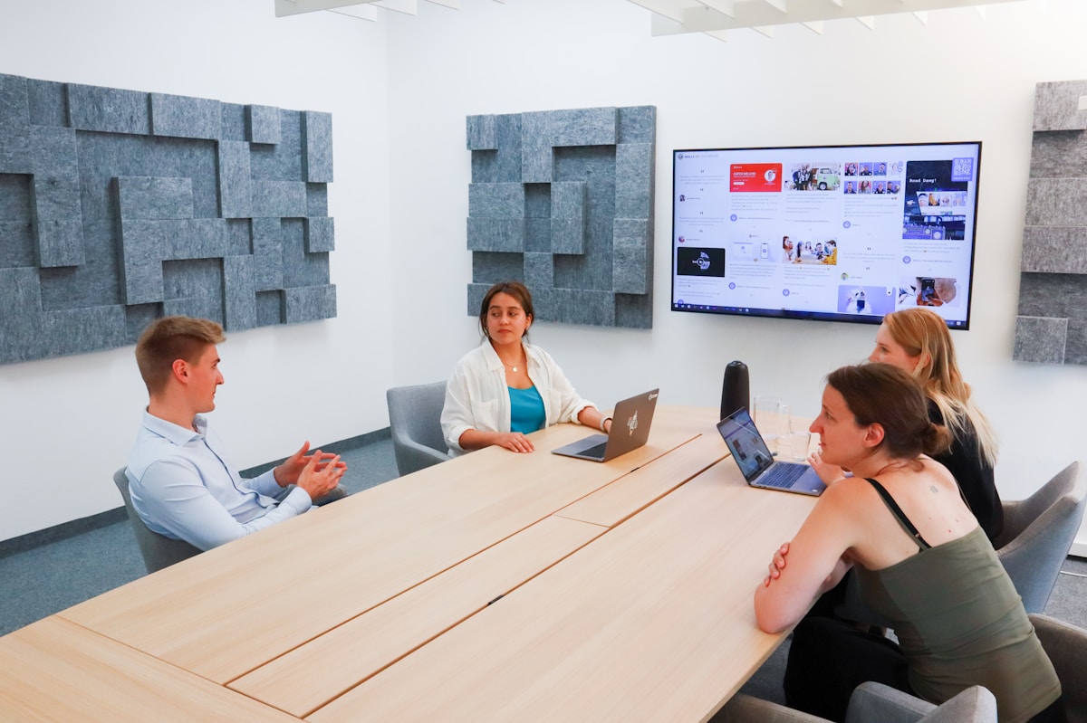 Réunion d'équipe dans un bureau moderne avec écran tactile.