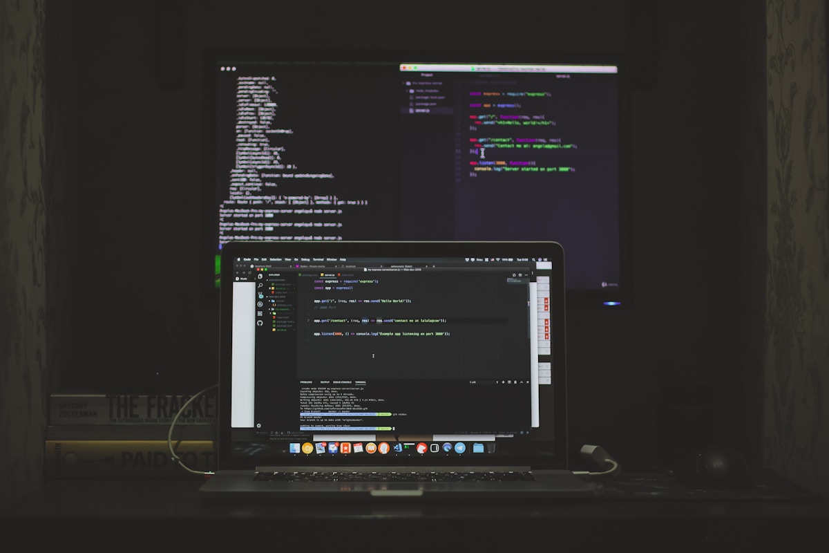 Écran d'ordinateur affichant du code de programmation et des fenêtres d'application.