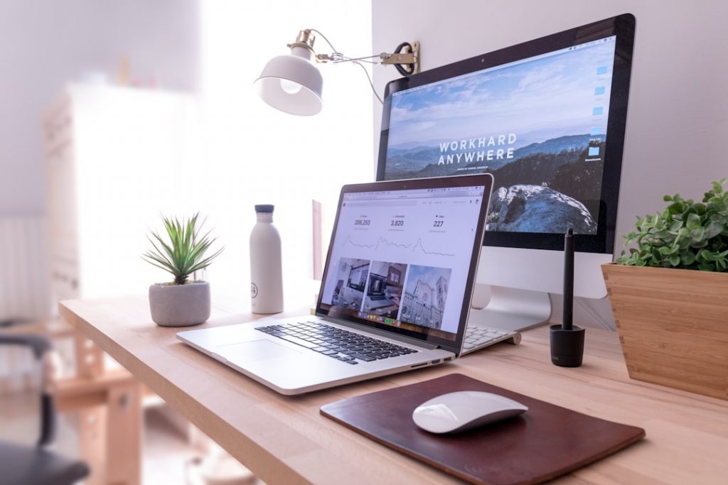 Un MacBook Pro et un iMac blanc avec une Magic Mouse sur une table, idéal pour la création du site internet.