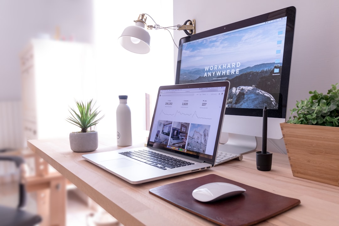 Un MacBook Pro et un iMac blanc avec une Magic Mouse sur une table, idéal pour la création du site internet.