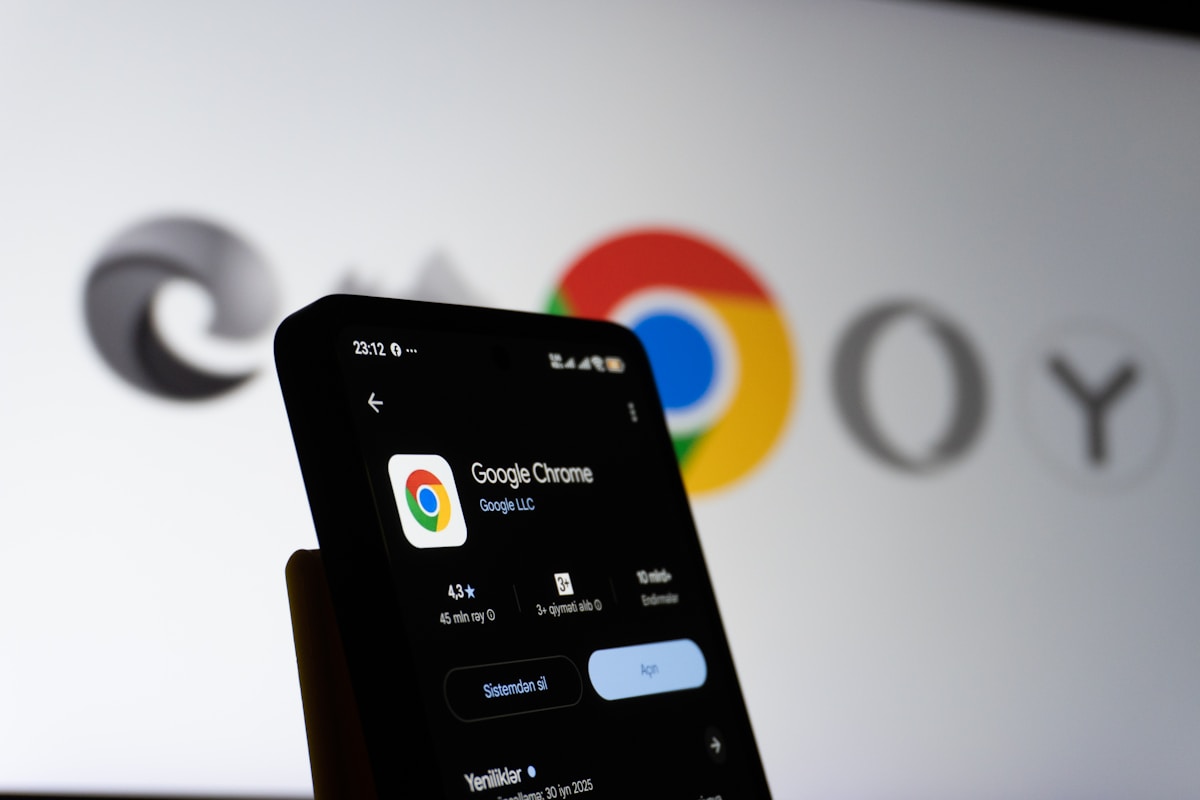 Smartphone affichant l'application Google Chrome sur un fond flou de logos Google.