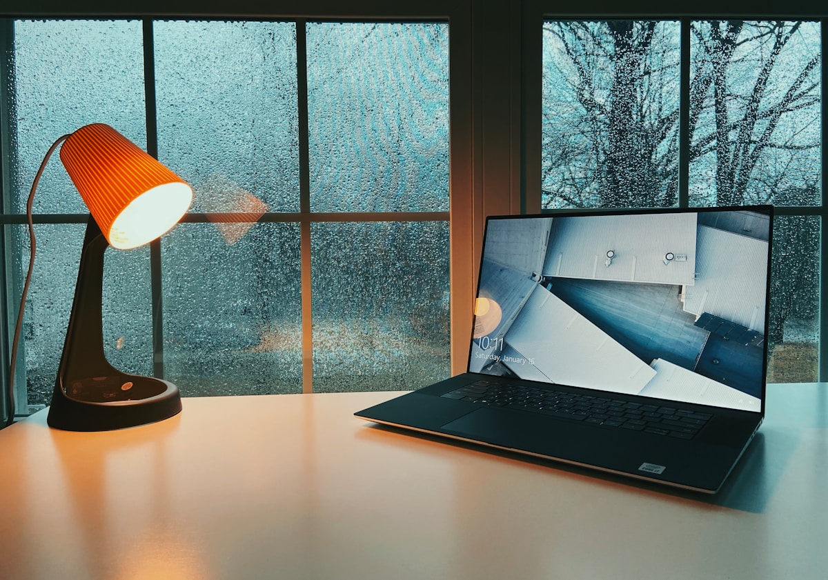 Bureau avec ordinateur portable et lampe de bureau.