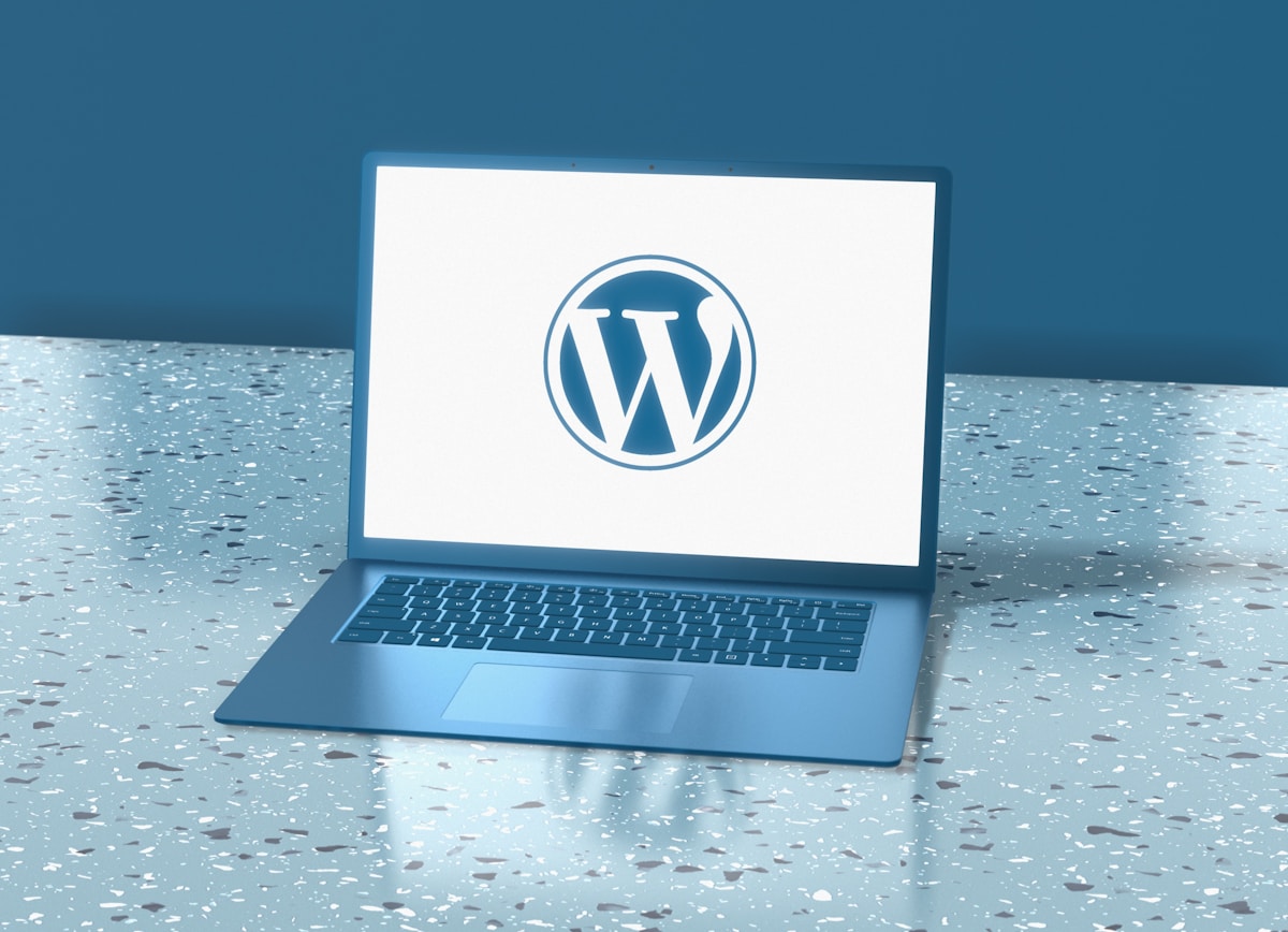 Ordinateur portable bleu avec le logo WordPress sur l'écran.