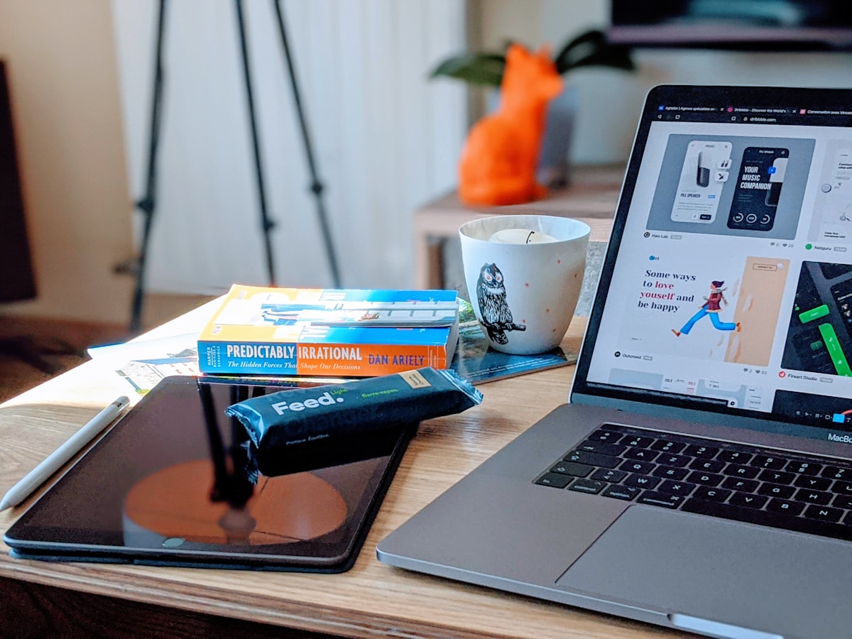 Bureau de travail avec ordinateur portable, livres, tasse et autres accessoires.