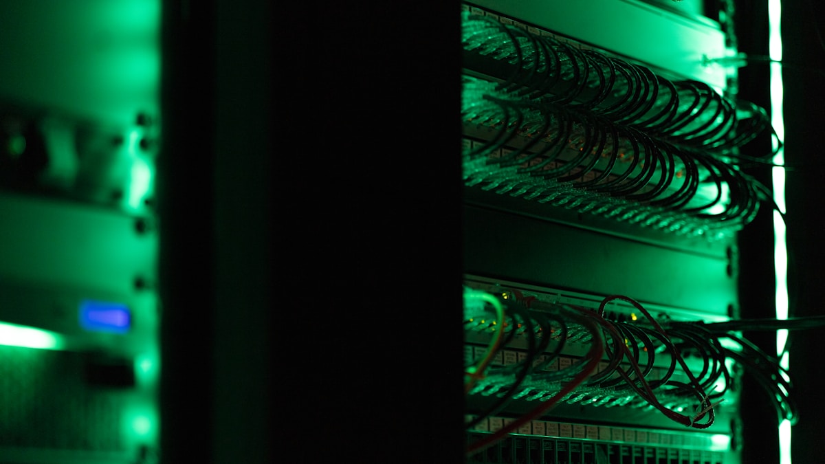 Serveurs informatiques dans une salle sombre avec éclairage vert.