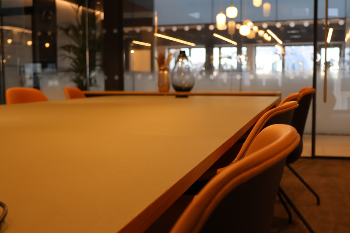 Table jaune avec chaises orange dans un restaurant.