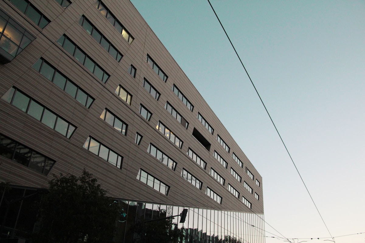 Bâtiment moderne à façade vitrée avec câbles électriques.