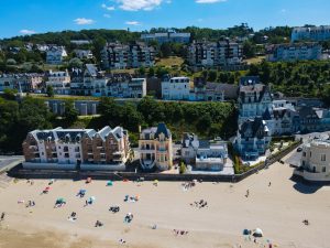 création site internet normandie - a beach with many buildings and trees