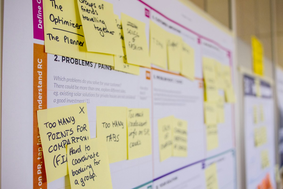 Post-it manuscrits sur tableau de planification collaborative coloré