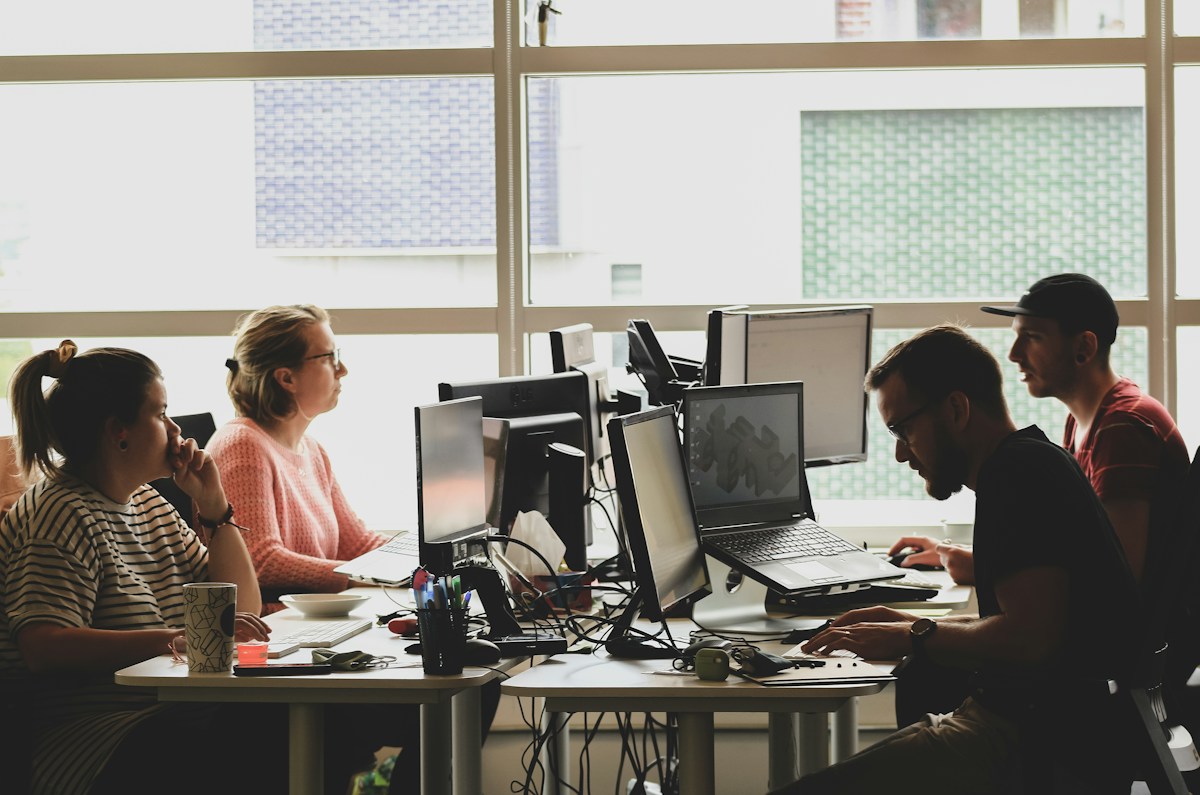 Équipe travaillant ensemble dans un bureau rempli d’ordinateurs